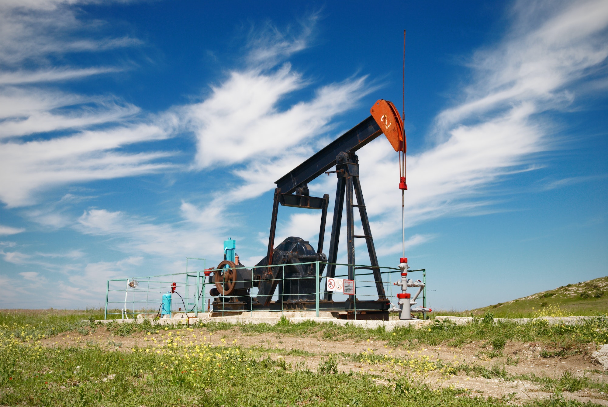 Oil pump. Oil industry equipment in green meadow