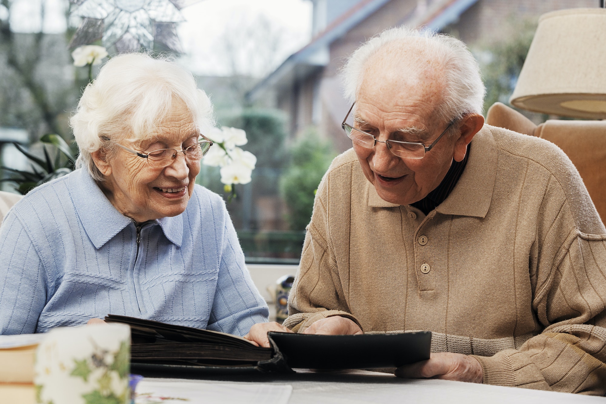 Senior couple watching old photographs at home