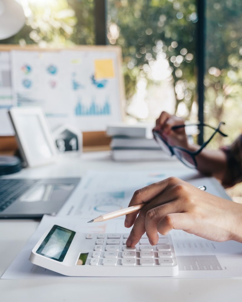 Business woman calculating domestic expenses involved in financial paperwork indoors, focused lady